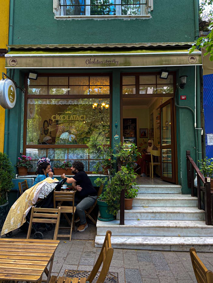 Cozy cafe with outdoor seating, plants, and lively conversation.